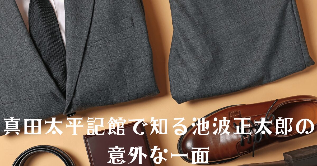 池波正太郎の真田太平記館を訪れる旅のアイキャッチ画像。グレーのスーツ、黒いネクタイ、革靴、ベルト、ノートが配置されたスタイリッシュな背景。