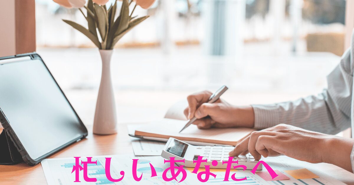 木製のデスクにノートパソコン、電卓、ノート、グラフの紙、チューリップの花が置かれ、人がペンで書いている様子が映る画像。デスク上にピンク文字で『忙しいあなたへ』と記載された、H2見出しのアイキャッチ画像